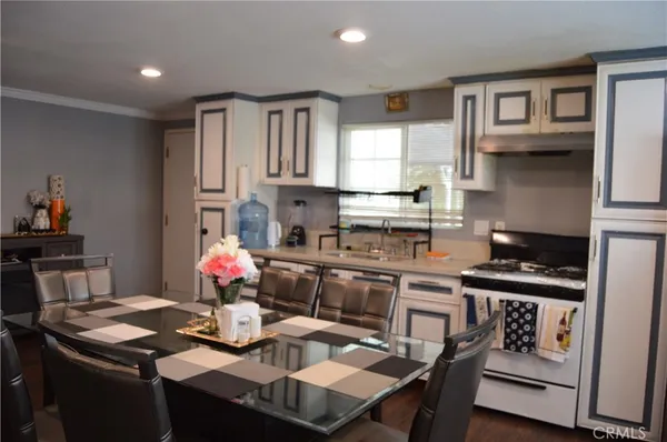 a kitchen with a table chairs stove and cabinets