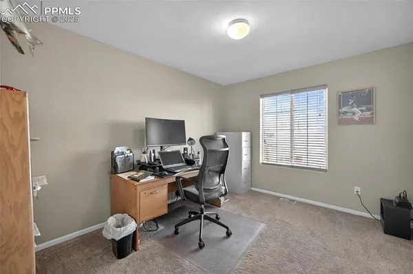 a view of a workspace with furniture and a window