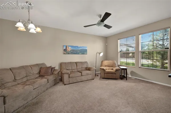 a living room with furniture chandelier and a large window