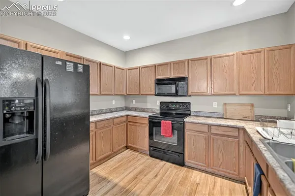 a kitchen with stainless steel appliances granite countertop a refrigerator sink and stove