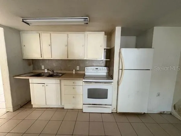 a kitchen with white cabinets and white appliances