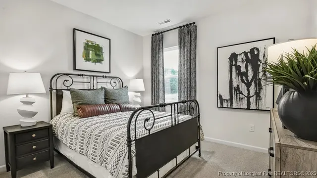 a bedroom with a bed and a flat tv screen on the dresser
