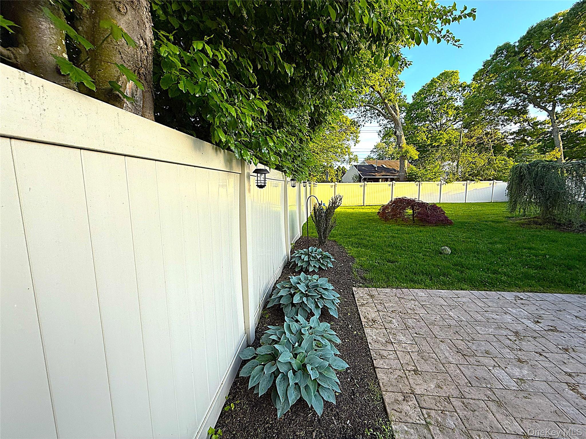 1 Heston Road Shirley, NY 11967 - Photo 29 of 32 Patio featuring paver flooring, bordered by a garden bed with hostas