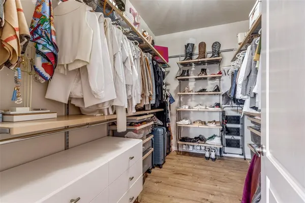a view of walk in closet with clothes and shoes