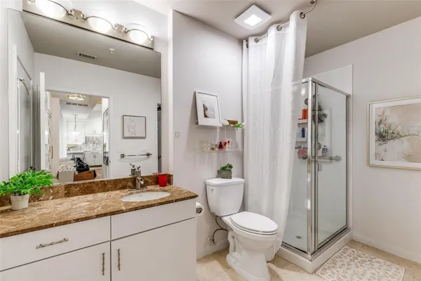 a bathroom with a granite countertop sink toilet and shower