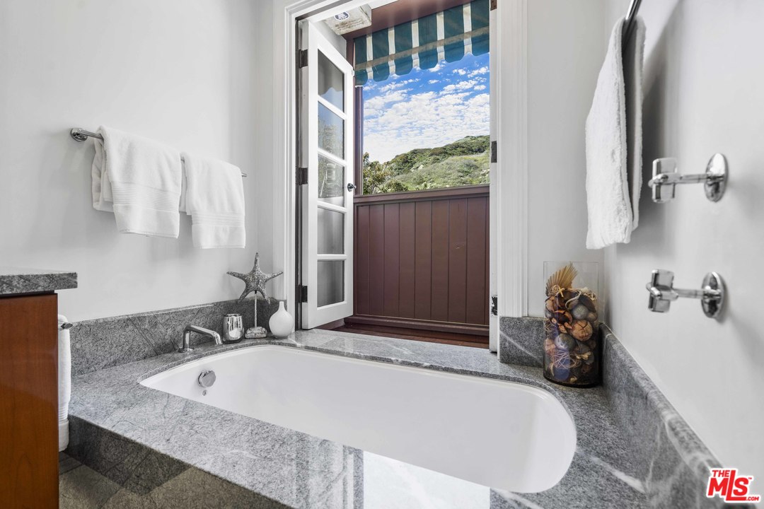 22630 Pacific Coast Highway Malibu, CA 90265 - Photo 14 of 24 a bathroom with a tub sink and mirror