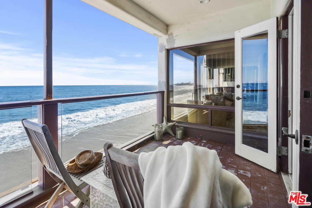 22630 Pacific Coast Highway Malibu, CA 90265 - Photo 18 of 24 a bedroom with a bed and glass door