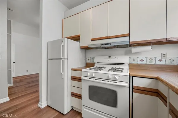 a kitchen with stainless steel appliances granite countertop a stove a refrigerator and cabinets