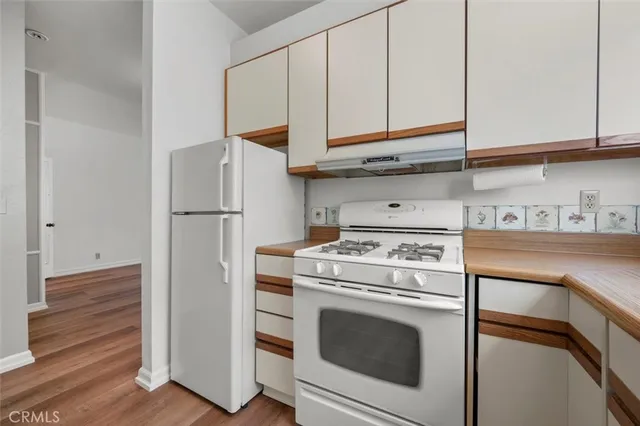 a kitchen with stainless steel appliances granite countertop a stove a refrigerator and cabinets