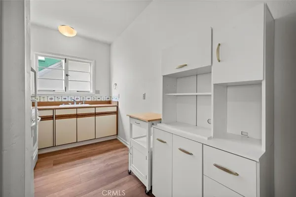 a kitchen with white cabinets and white appliances