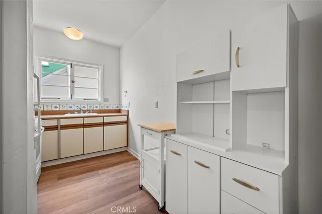 a kitchen with white cabinets and white appliances
