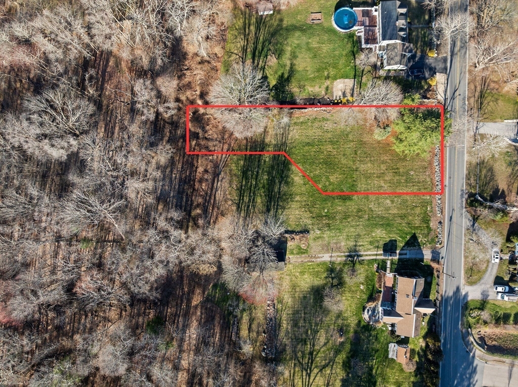 an aerial view of residential house with outdoor space and trees