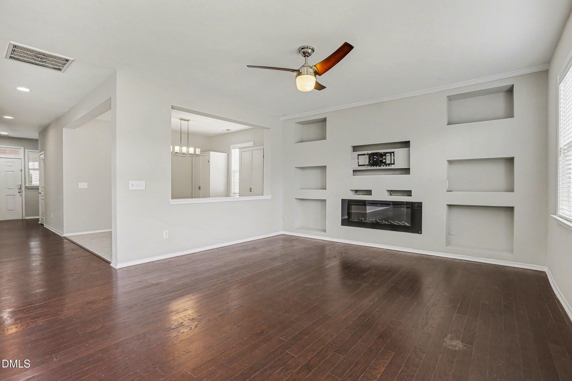 132 Daneborg Road Durham, NC 27703 - Photo 11 of 37 an empty room with wooden floor kitchen view and a window
