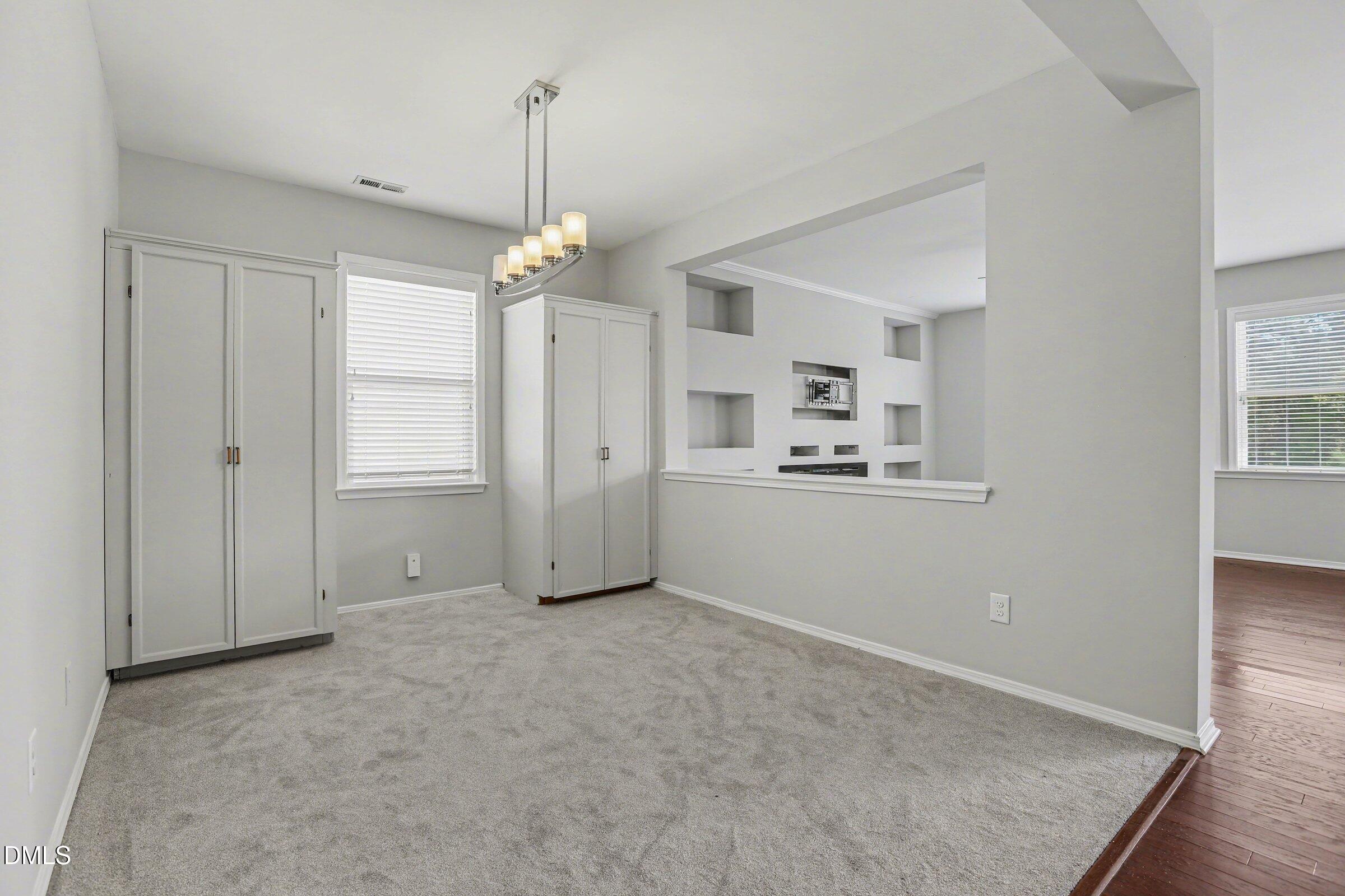 132 Daneborg Road Durham, NC 27703 - Photo 13 of 37 an empty room with chandelier fan and windows