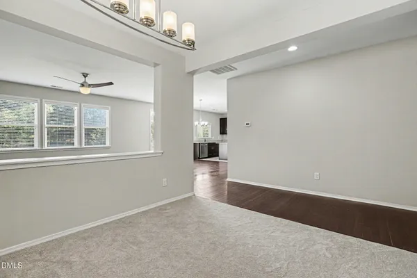 a view of empty room with wooden floor and windows