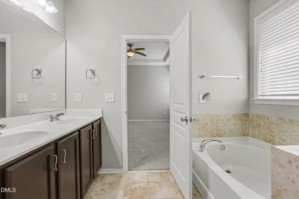 a bathroom with a tub sink and mirror
