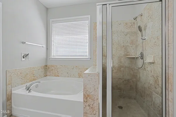 a white bath tub sitting next to a shower