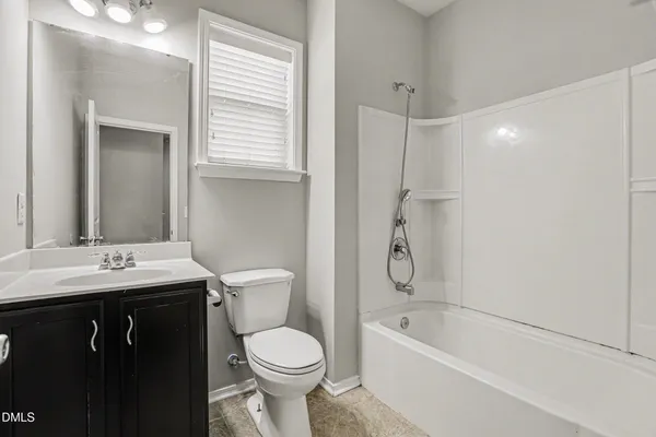 a bathroom with a granite countertop sink a toilet and bathtub