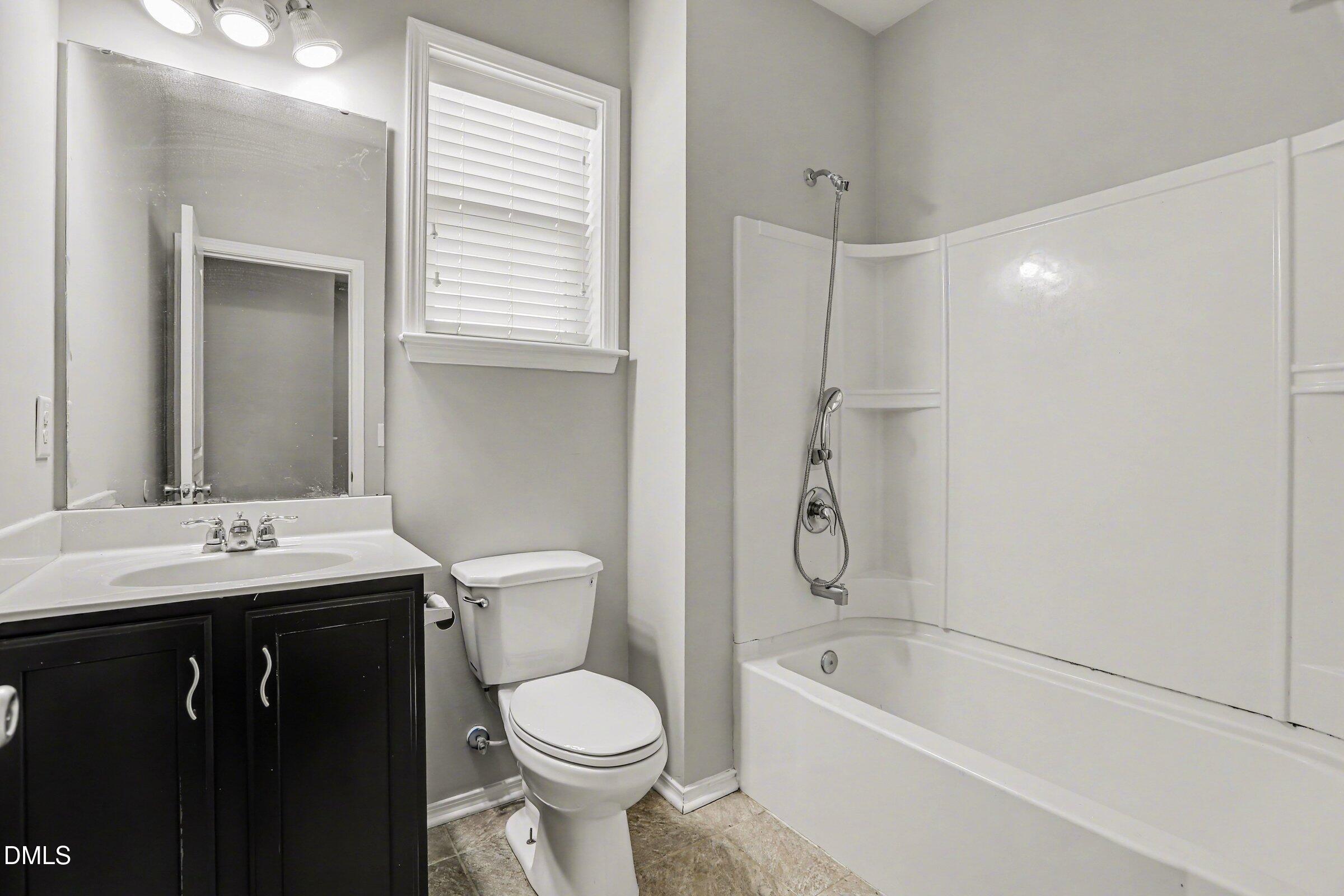 132 Daneborg Road Durham, NC 27703 - Photo 31 of 37 a bathroom with a granite countertop sink a toilet and bathtub