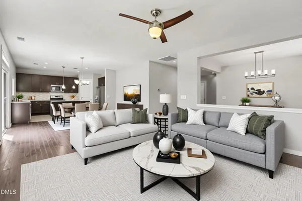 a living room with furniture kitchen view and a chandelier