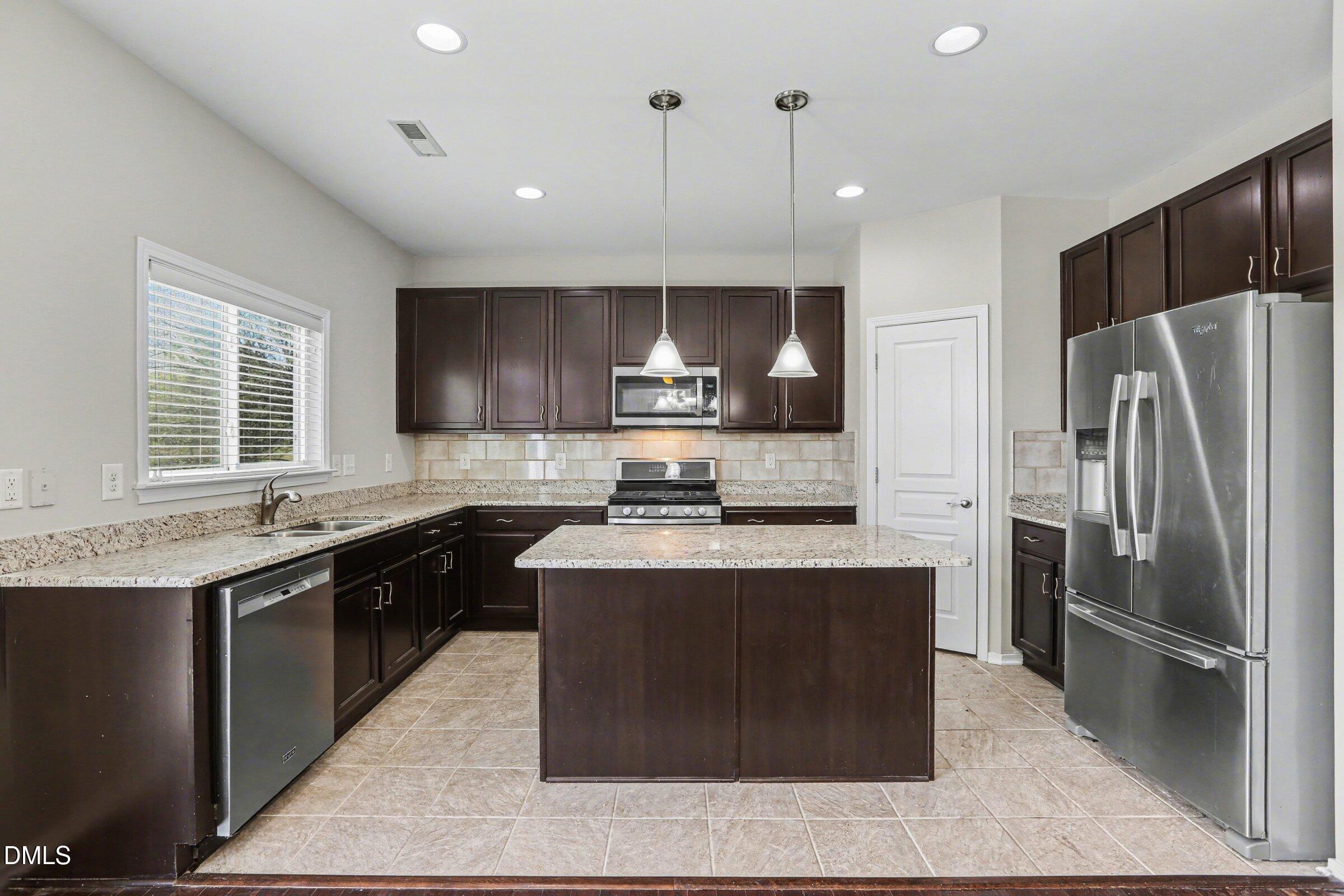 132 Daneborg Road Durham, NC 27703 - Photo 7 of 37 a kitchen with stainless steel appliances granite countertop a stove a sink a refrigerator and a microwave