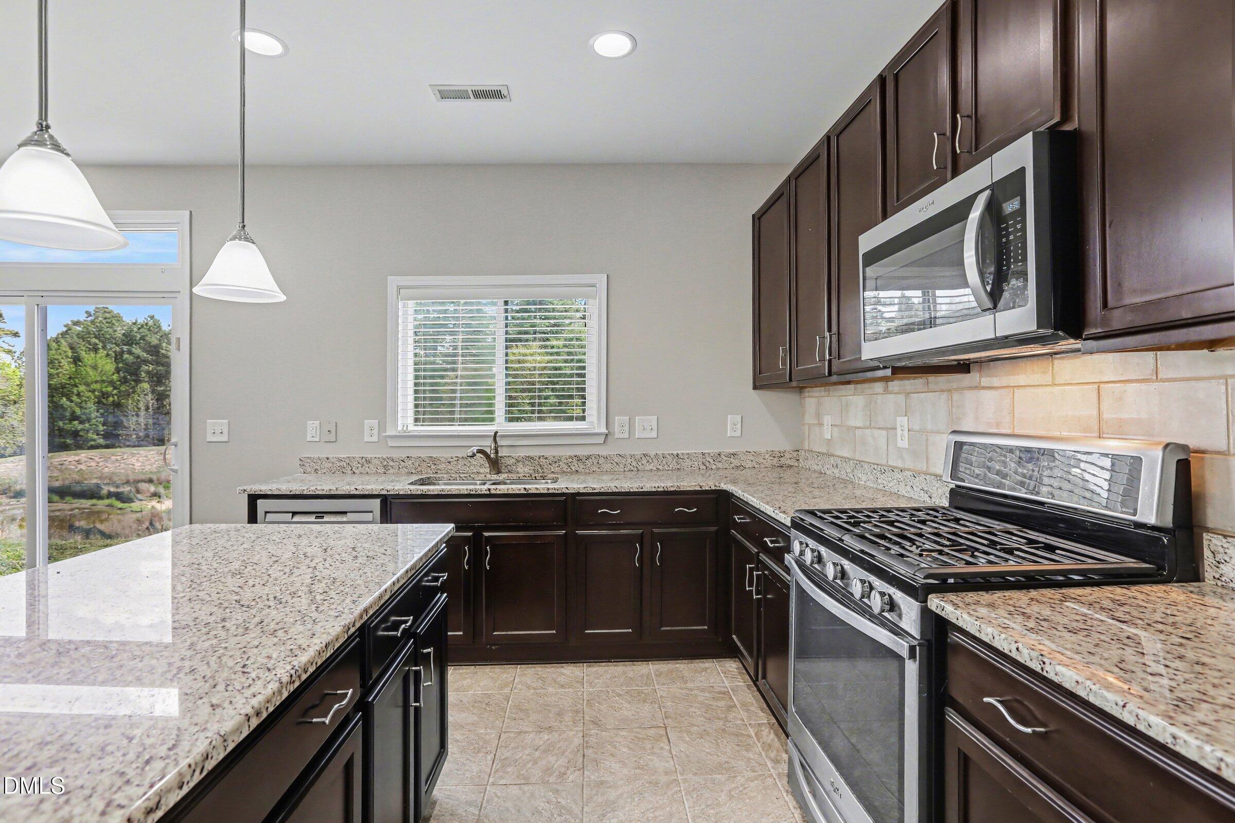 132 Daneborg Road Durham, NC 27703 - Photo 8 of 37 a kitchen with stainless steel appliances granite countertop a sink stove and microwave