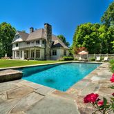 a front view of a house with swimming pool and yard