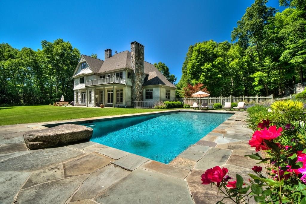a front view of a house with swimming pool and yard