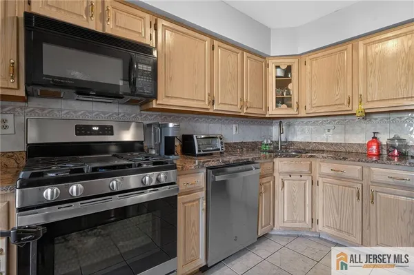 a kitchen with stainless steel appliances granite countertop a stove microwave and sink