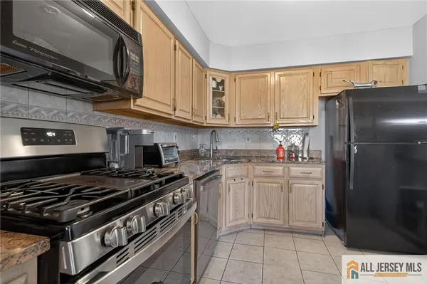 a kitchen with stainless steel appliances granite countertop a stove a refrigerator and a microwave