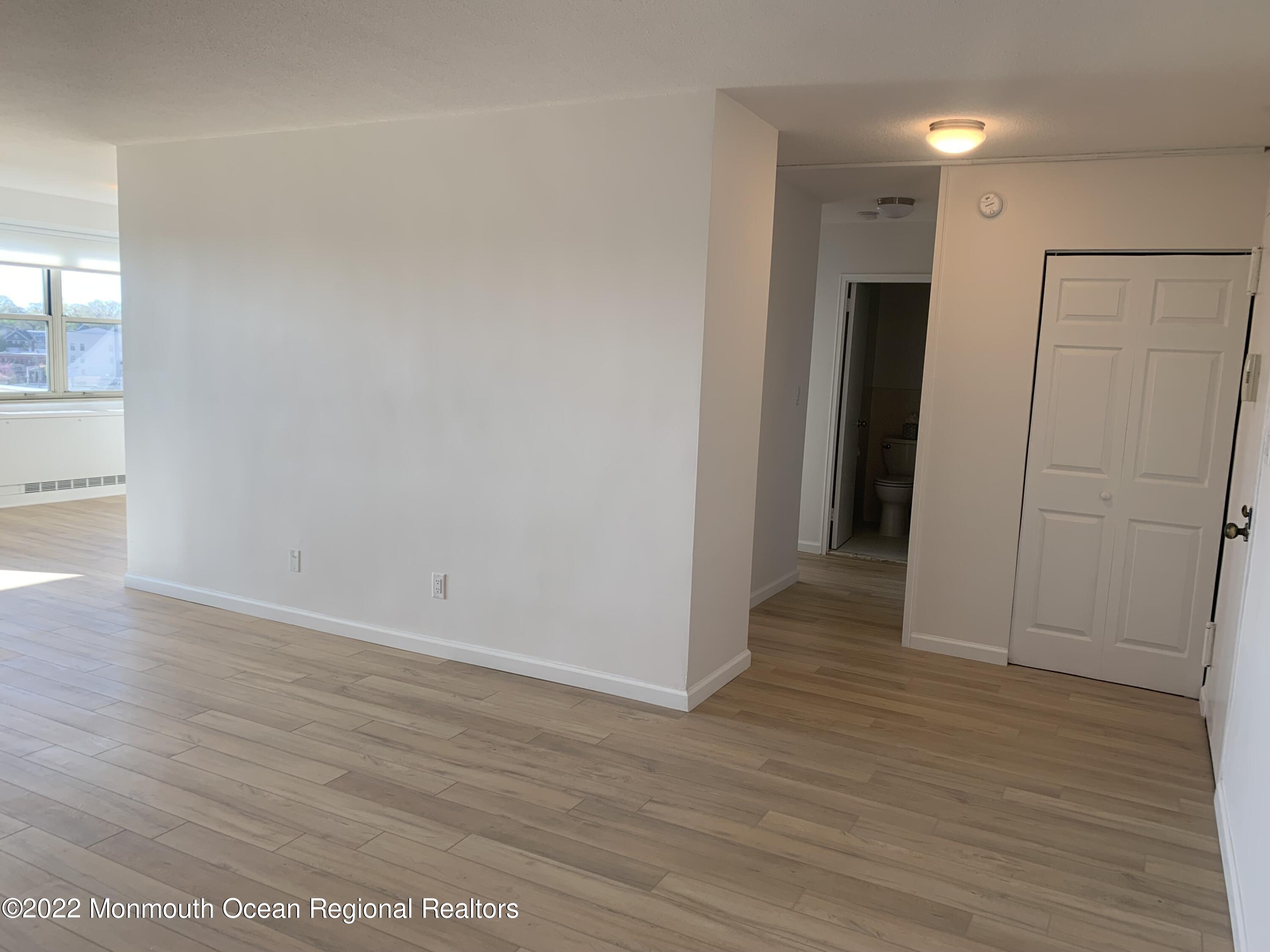 28 Riverside Avenue, Unit 6C Red Bank, NJ 07701 - Photo 11 of 26 an empty room with wooden floor and entrance