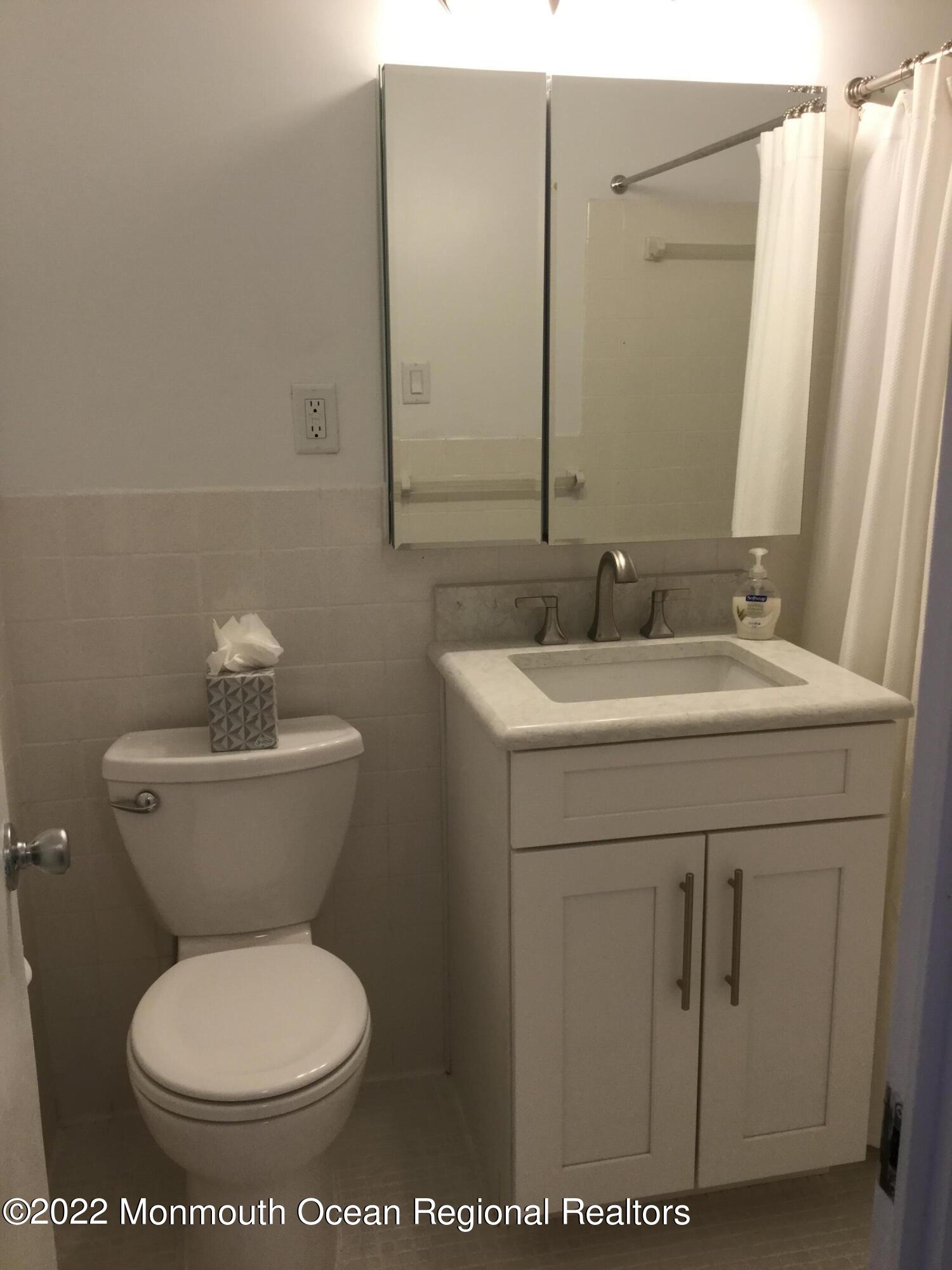 28 Riverside Avenue, Unit 6C Red Bank, NJ 07701 - Photo 14 of 26 a bathroom with a toilet sink and mirror