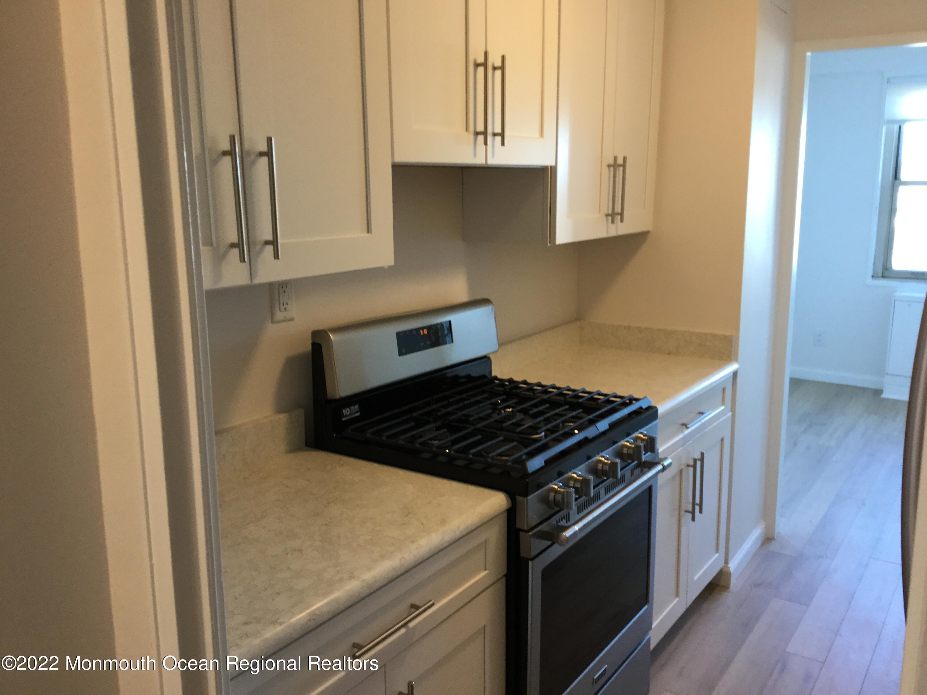 28 Riverside Avenue, Unit 6C Red Bank, NJ 07701 - Photo 5 of 26 a kitchen with granite countertop a stove and a white refrigerator