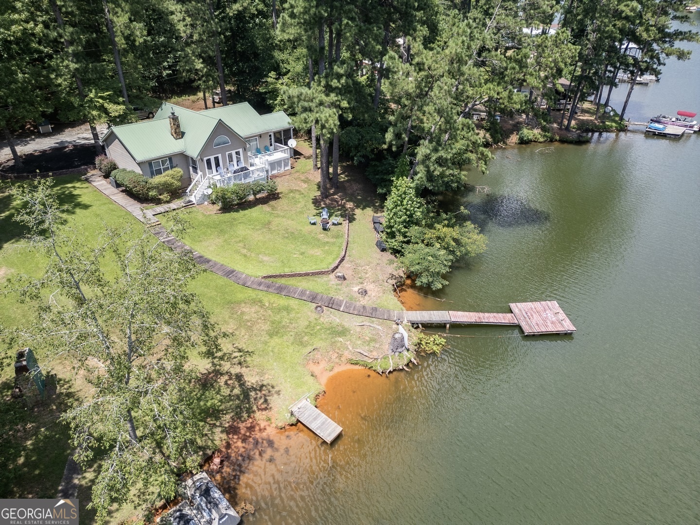 an aerial view of a house with swimming pool and lake view