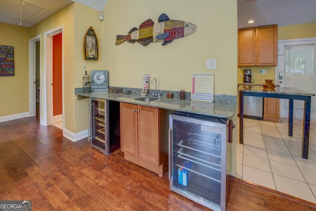 a kitchen with granite countertop a sink cabinets and wooden floor