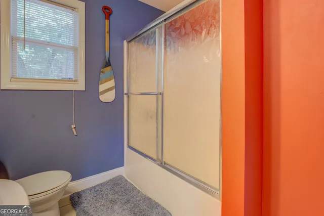 a bathroom with a granite countertop sink and a toilet