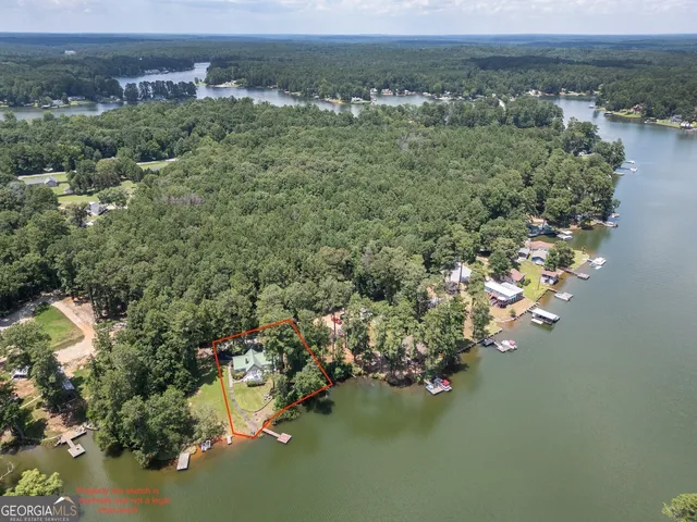 an aerial view of a houses with a yard and lake view