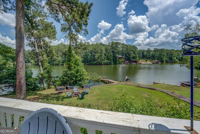a view of a lake with a yard and a large tree
