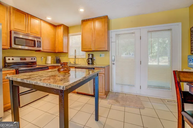 a kitchen with stainless steel appliances granite countertop a sink and a refrigerator