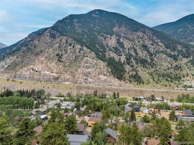 a view of a house with a mountain and a forest