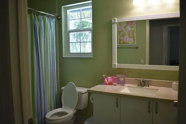 a bathroom with a sink vanity mirror and toilet