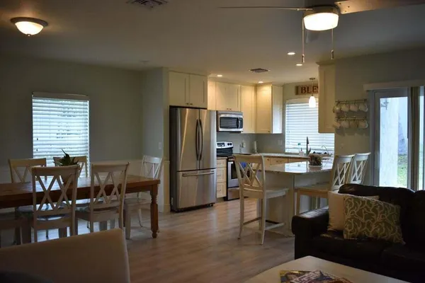 a kitchen with a dining table chairs refrigerator and cabinets