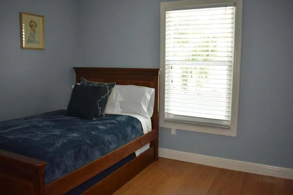 a bed sitting in a bedroom next to a window