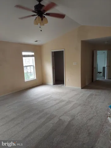 a view of a big room with windows and chandelier fan