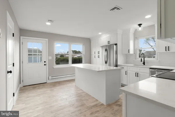 a large kitchen with stainless steel appliances kitchen island granite countertop a sink and cabinets