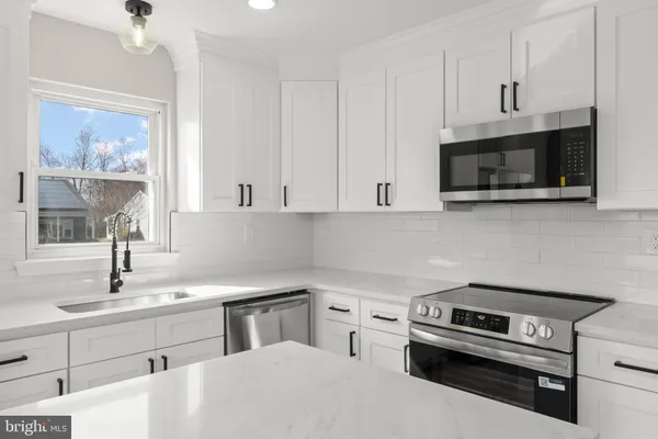 a kitchen with stainless steel appliances a stove a microwave and sink