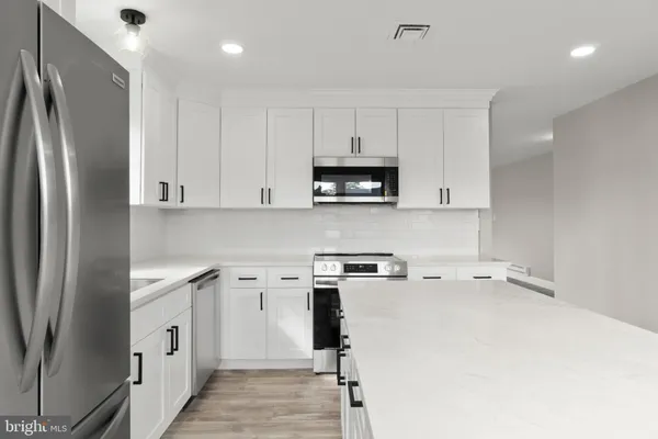 a kitchen with a refrigerator a stove a microwave and cabinets