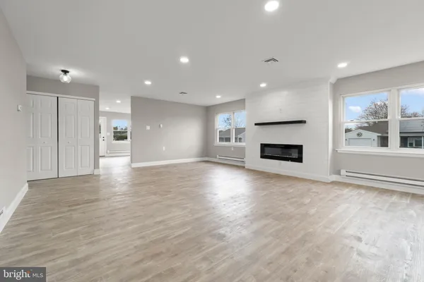 a view of empty room with a fireplace and wooden floor