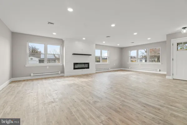 a view of empty room with a fireplace and wooden floor
