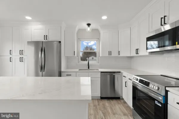 a kitchen with stainless steel appliances a stove a sink and a microwave